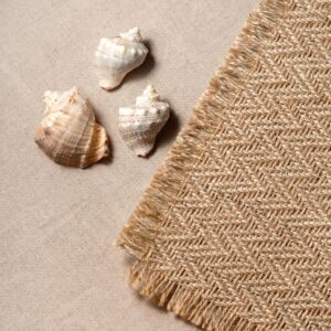 Minimal square aesthetic neutral summer vacation concept with sea shells and jute rug on a beige background, copy space